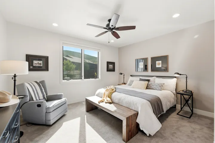 Spacious room with light-colored walls, recessed ceiling lighting, and a ceiling fan