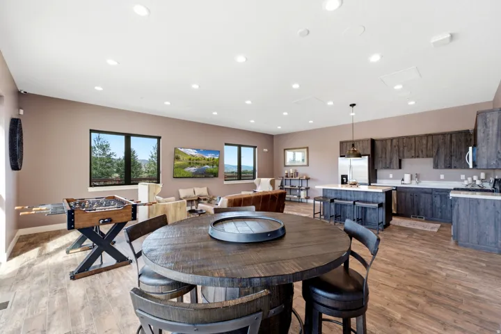 Open-concept living area with wood-finish flooring, recessed lighting, and large windows