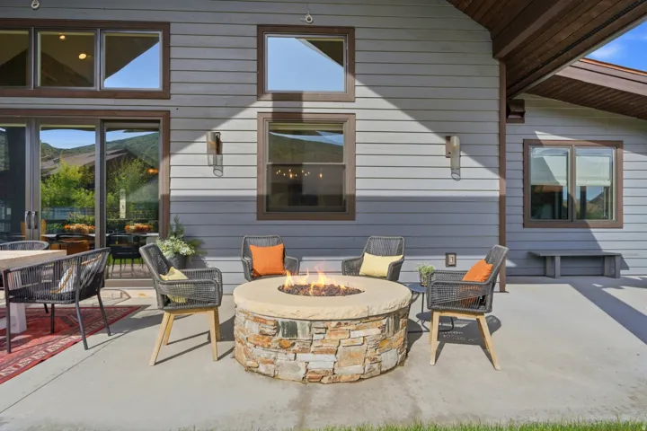 Expansive concrete patio with a stone-clad fire pit
