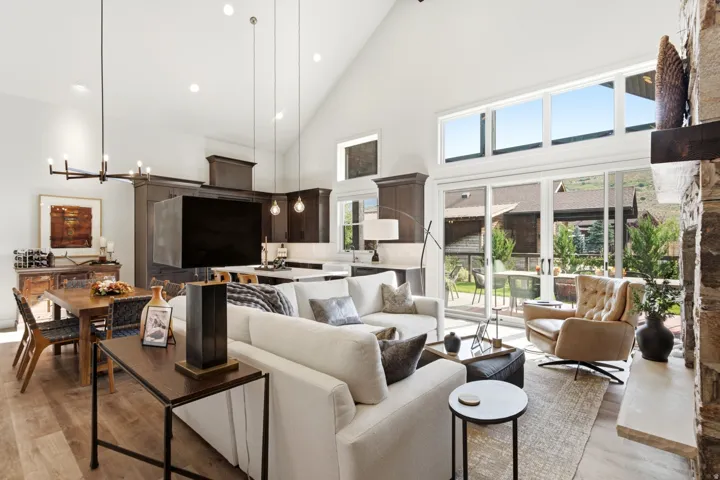 Soaring vaulted ceilings, wood-finish flooring, and a stone-clad fireplace