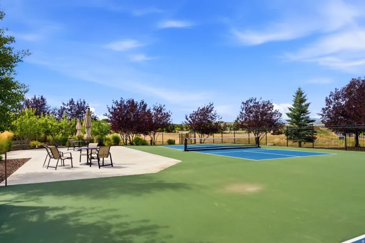 Recreational court, concrete patio, mature landscaping, and perimeter fencing