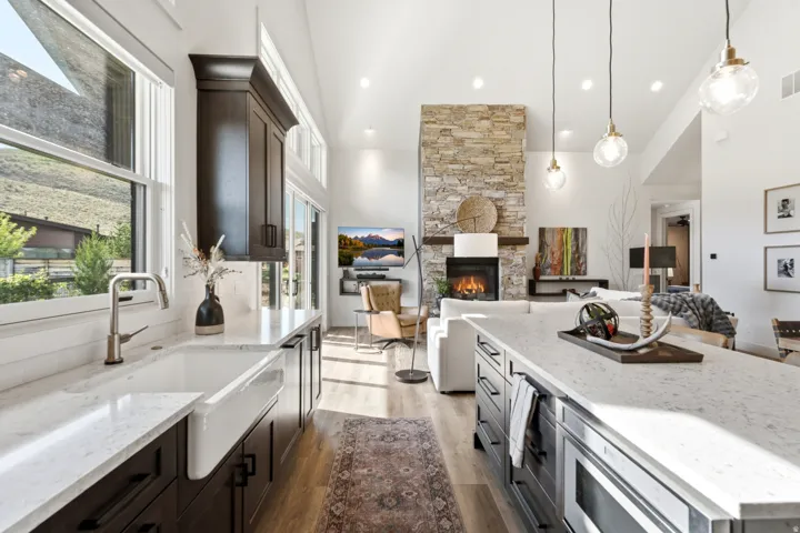 Gourmet kitchen with an apron-front sink, quartz countertops, and dark wood-finish cabinetry