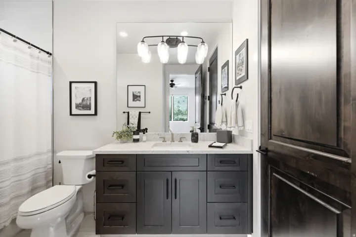 Dark wood-finish vanity with drawer and cabinet storage, light-toned countertop, and integrated sink