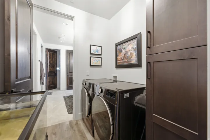 Laundry area featuring wood-finish flooring, built-in cabinetry, and recessed lighting