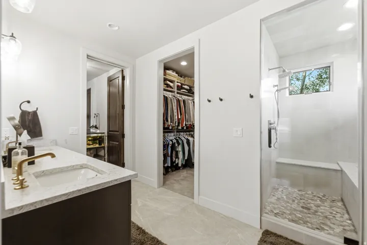Vanity with an integrated sink, gold-tone faucet, and stone countertop