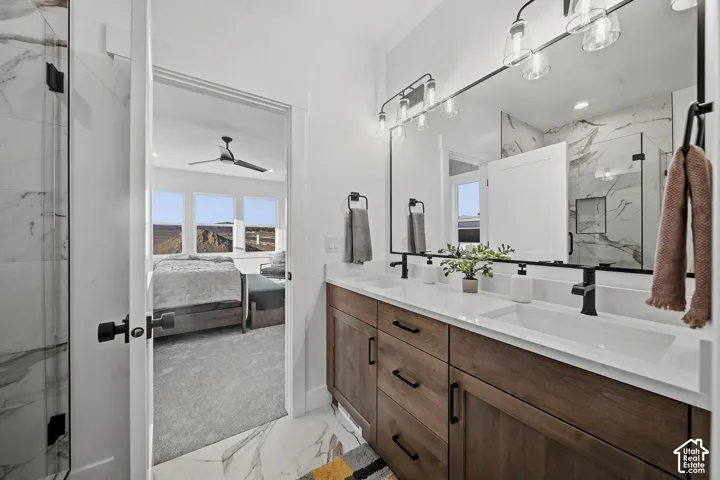 Dual vanity with wood-finish cabinetry, white countertops, and matte black fixtures