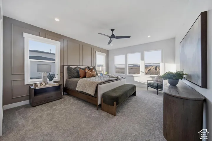 Recessed lighting, ceiling fan, accent wall with panel molding, carpeted flooring, multiple windows