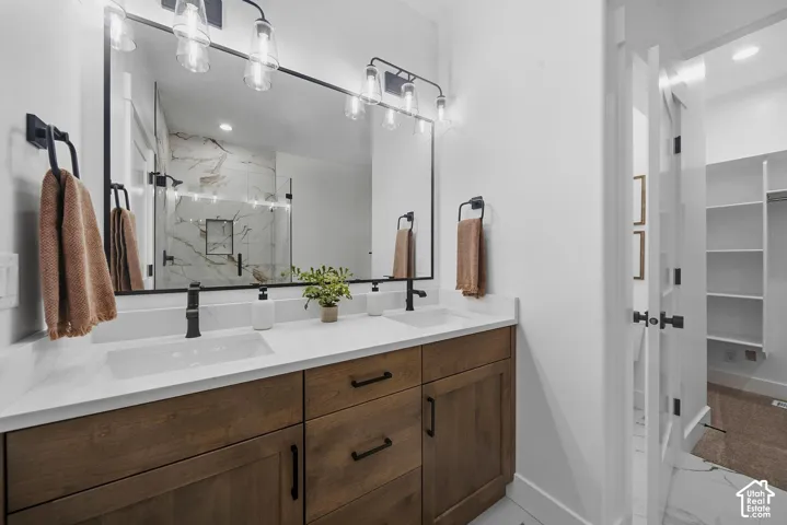 Double vanity with wood-finish cabinetry, white countertops, and matte black fixtures