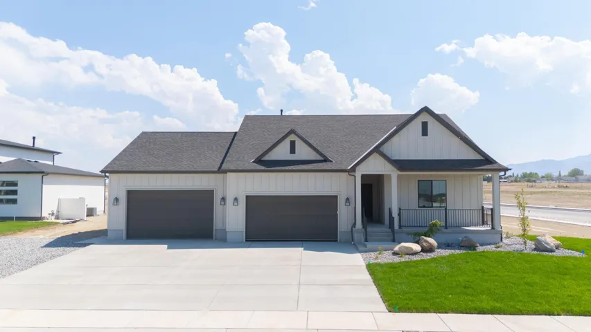 Contemporary farmhouse-style exterior with a dark shingle roof, attached two-car garage, covered entry porch, and a concrete driveway