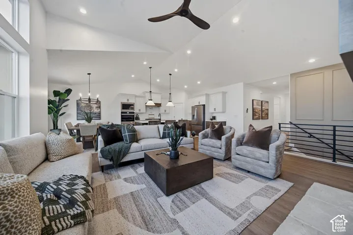 Vaulted ceiling with an exposed beam, wood-finish flooring, recessed lighting, and a modern ceiling fan