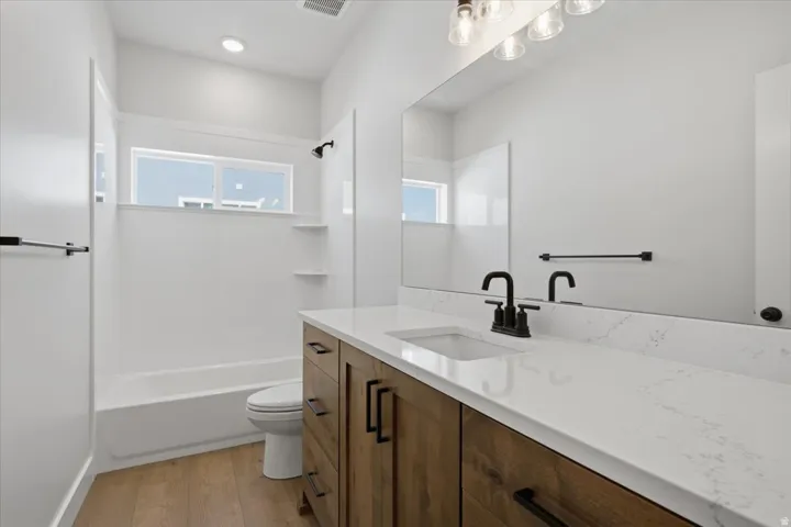 Modern vanity with a light wood-finish base and white countertop