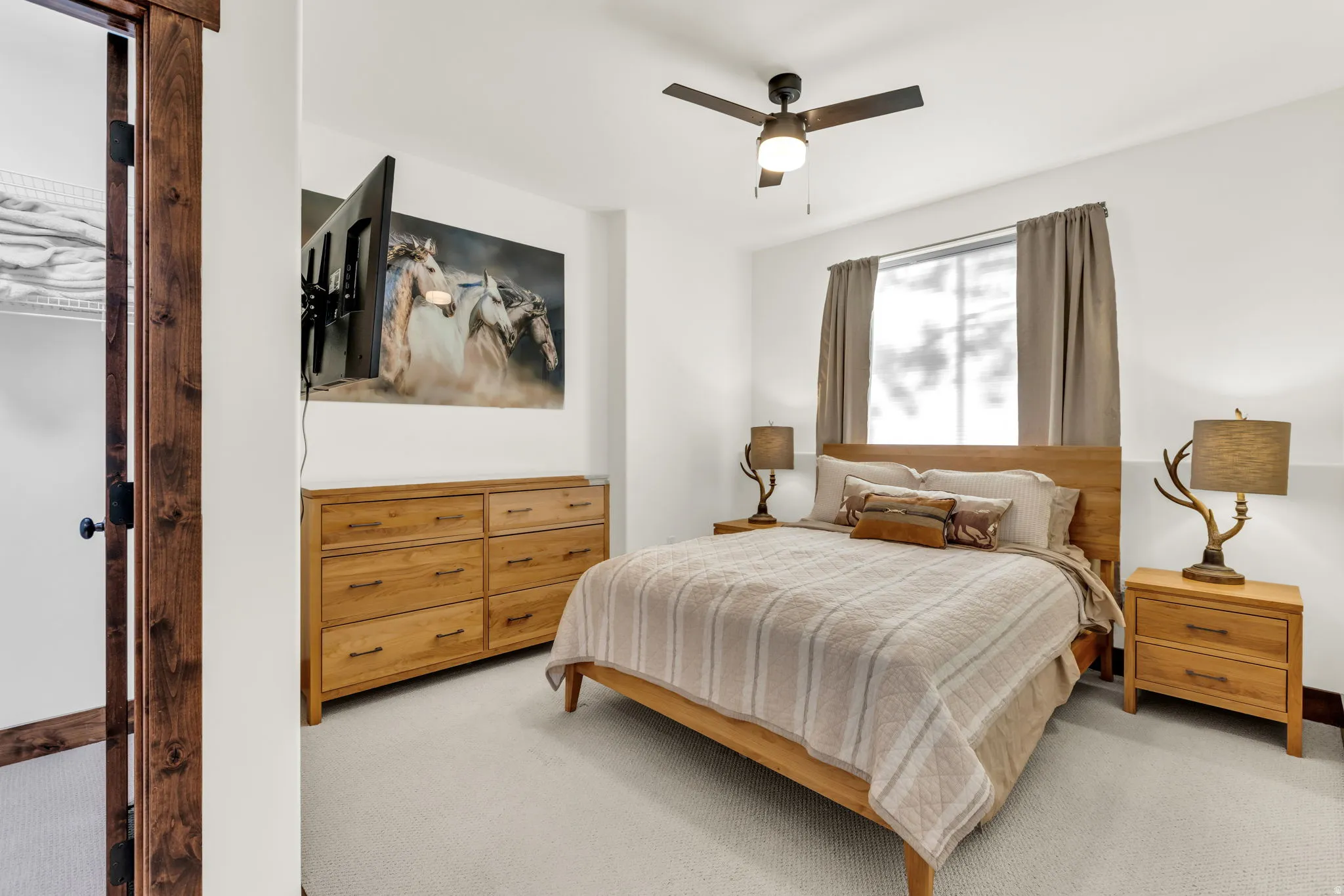 White walls with a single window, a ceiling fan, and carpeted flooring
