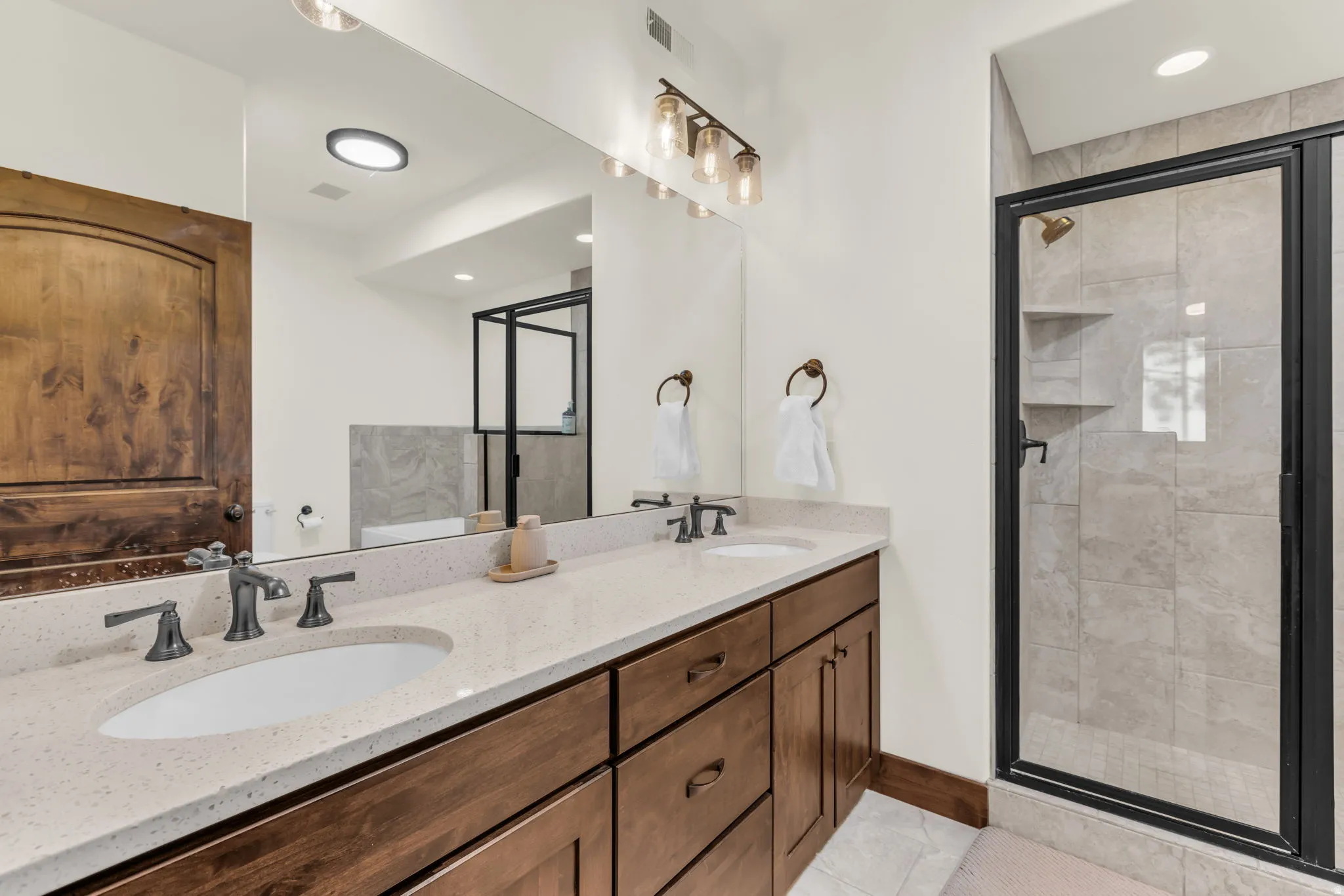 Dual vanity with undermount sinks, quartz-finish countertop, and dark-toned cabinetry
