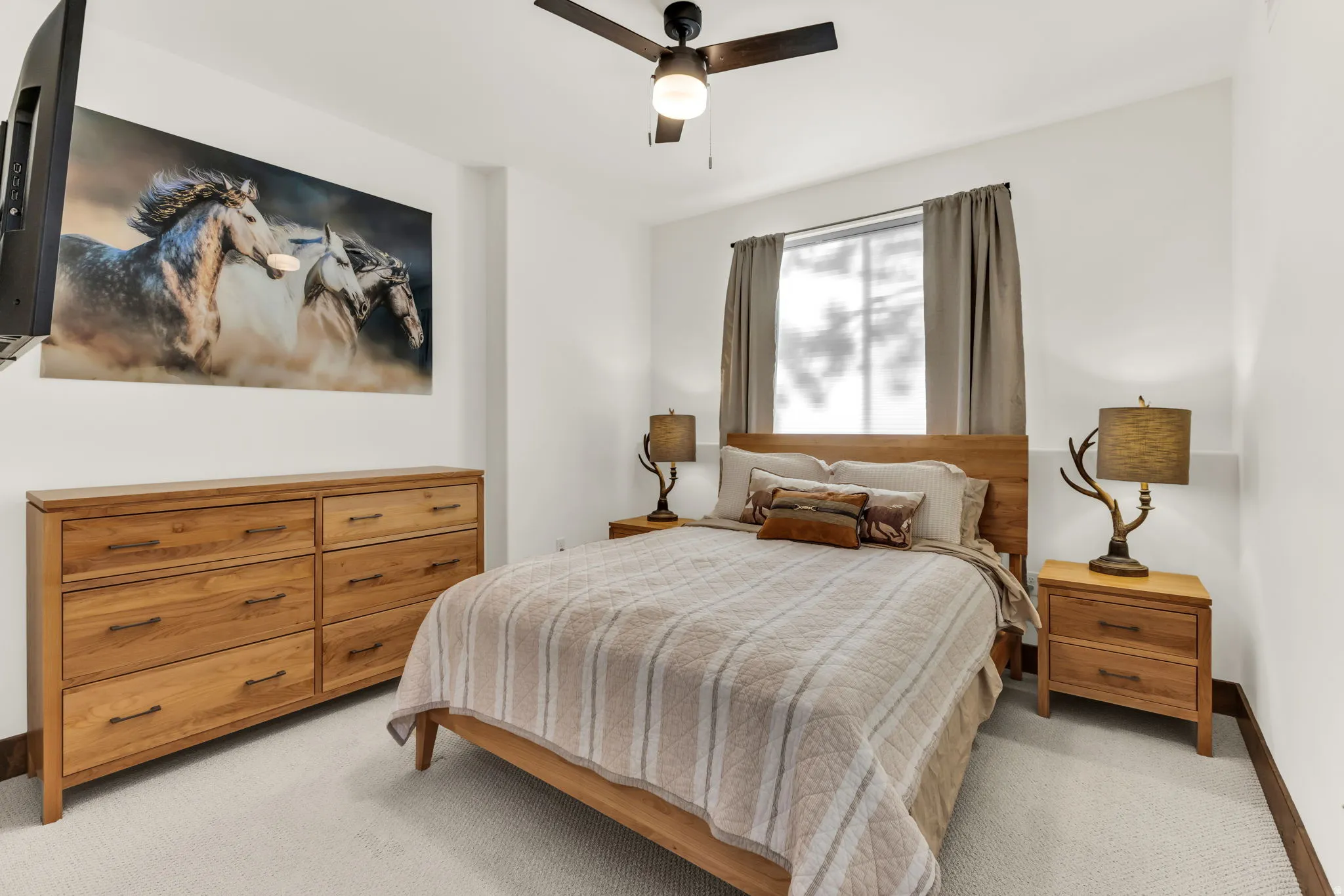 White walls and light-toned carpeting with a ceiling fan