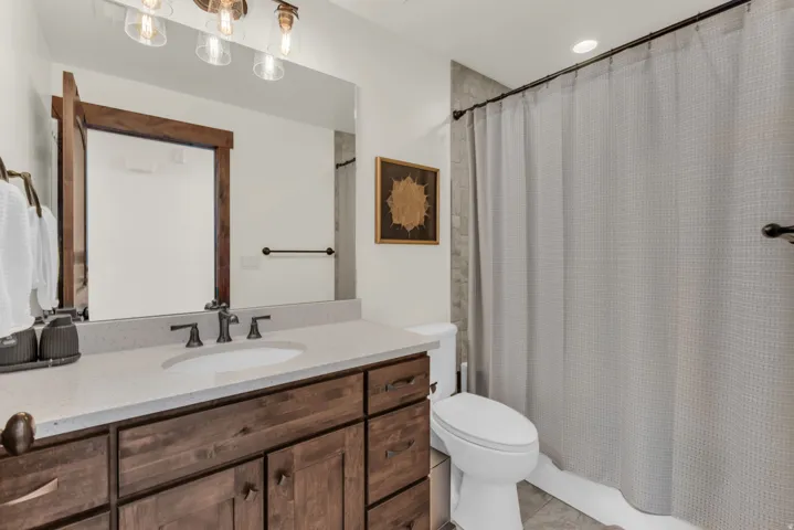 Wood-finish vanity with an integrated sink, light-colored countertop, and dark-toned faucet