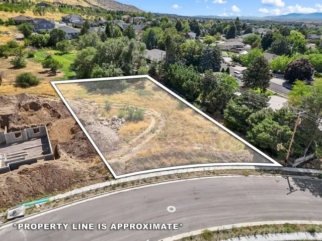 Developable land parcel with an established road frontage, surrounded by residential properties and mature trees