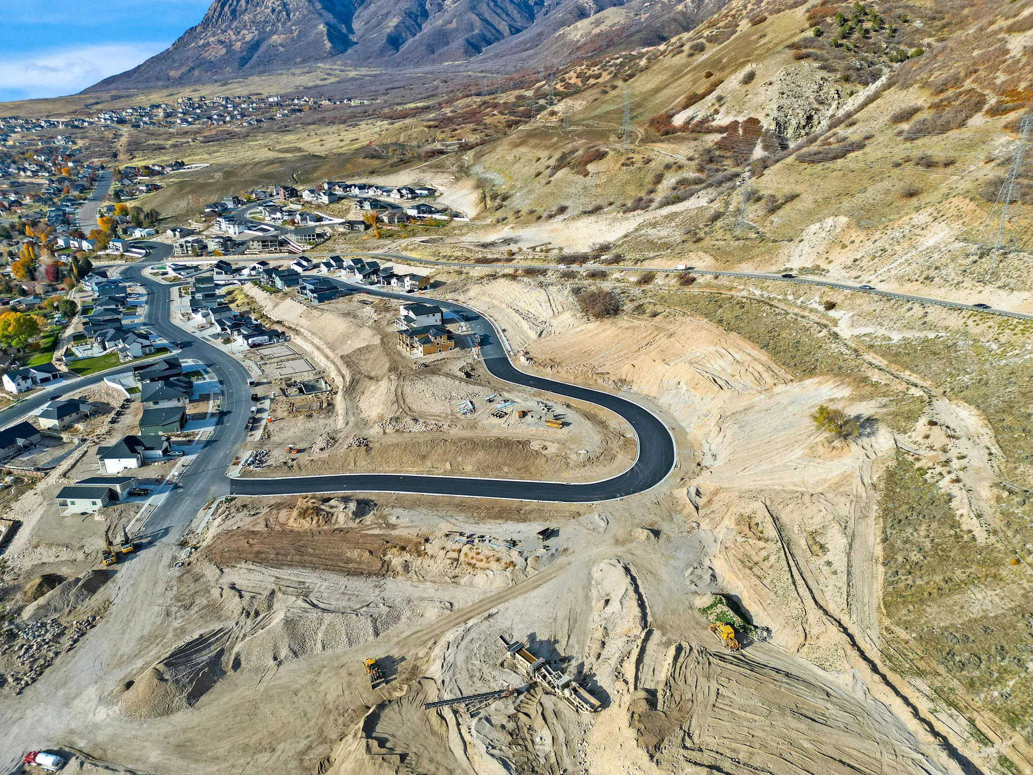 New construction development with paved roads and surrounding mountain terrain