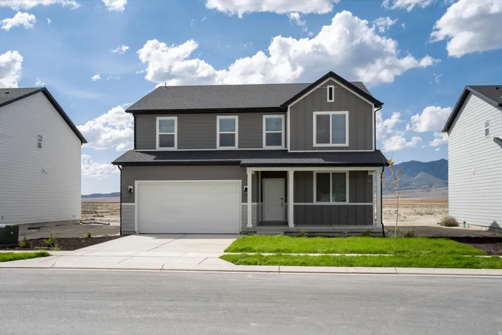 **DISCLAIMER** Exterior package may vary. Two-story residence featuring gray siding with white trim, a covered front porch, and an attached two-car garage