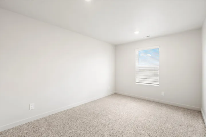 **DISCLAIMER** Interior package may vary. Recessed ceiling lighting, a single window with horizontal blinds, light-toned carpeting, and light-colored wall finishes
