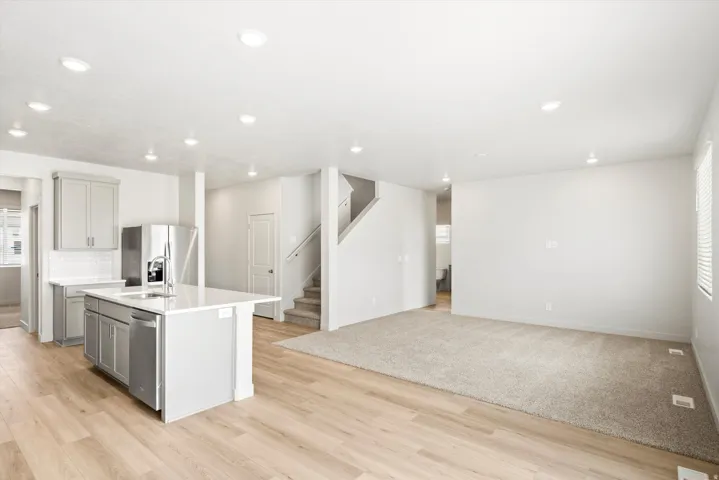 **DISCLAIMER** Interior package may vary. Open-concept living space featuring wood-finish flooring, recessed lighting, and a kitchen island with integrated stainless steel appliances