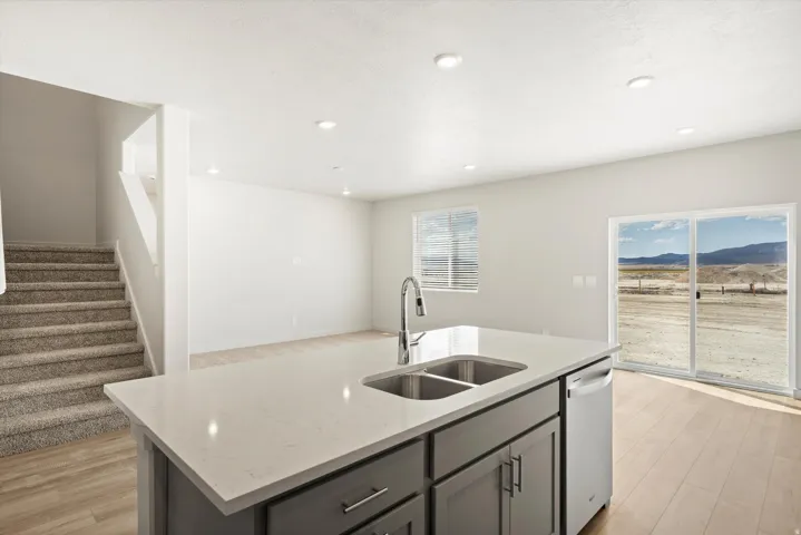 **DISCLAIMER** Interior package may vary. Kitchen island with a dual basin sink and a high-arc faucet, quartz-finish countertop, and gray cabinetry