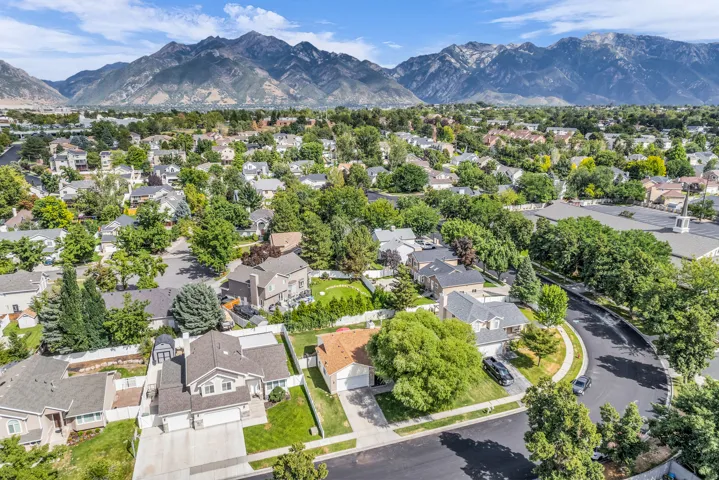 Residential neighborhood featuring mature trees and mountain scenery