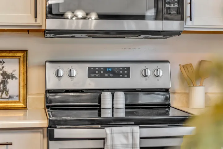 Stainless steel appliance suite featuring a built-in microwave and electric range