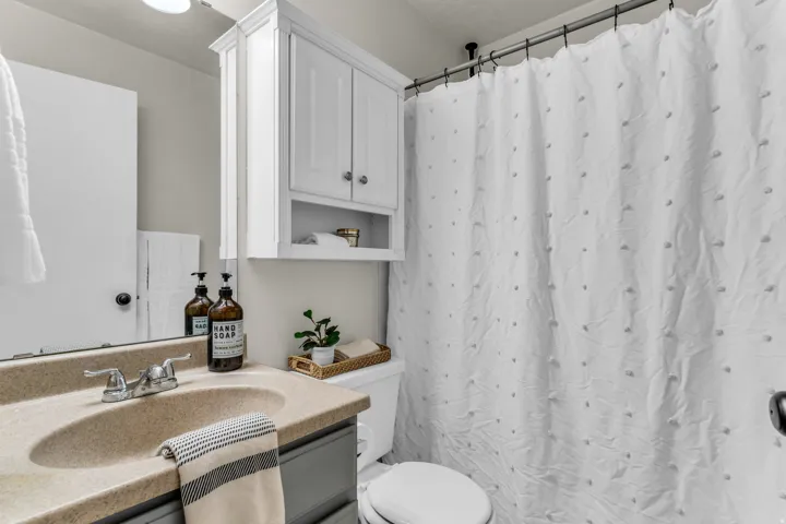Bathroom vanity with a neutral-toned countertop and chrome faucet