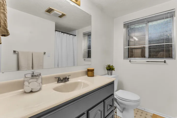 Vanity with an integrated sink, dual-handle faucet, and dark-finished cabinetry