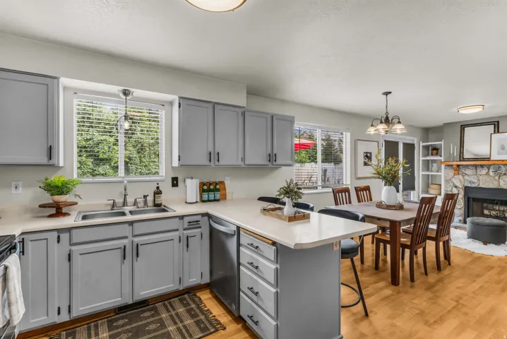 Kitchen featuring gray shaker-style cabinetry, a double basin stainless steel sink, and light countertops