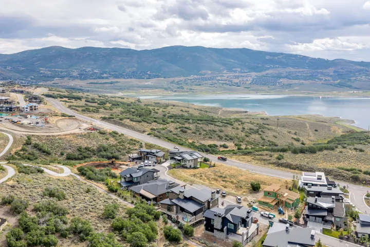 Sprawling landscape featuring a large body of water, distant mountains, and a collection of residential properties