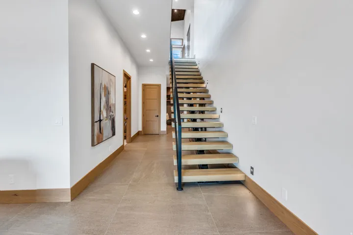 Floating staircase with wood treads and a black metal railing