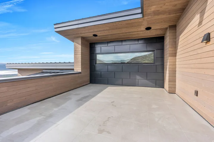 Expansive exterior terrace featuring large format tile flooring and horizontal wood siding