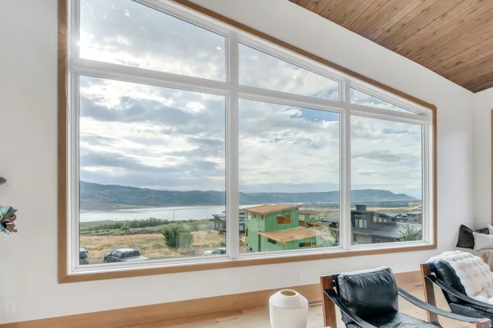 Expansive window wall with natural wood trim, wood-finish flooring, and a wood-paneled ceiling