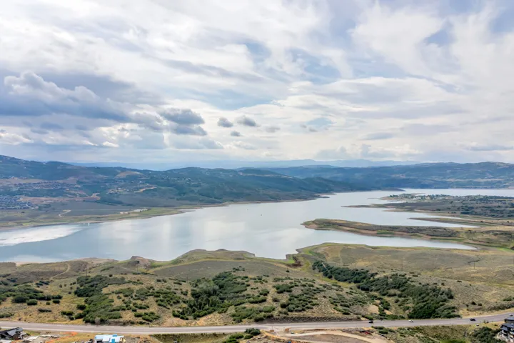 Expansive water body with surrounding natural landscapes and distant mountainous terrain