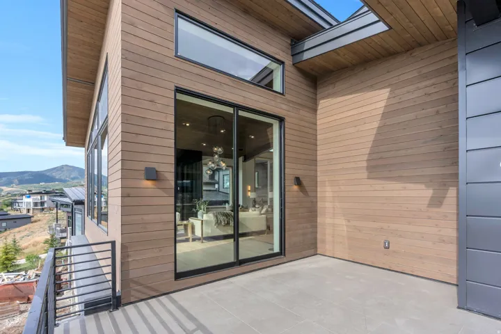 Private balcony featuring light-toned tile flooring and dark metal railings