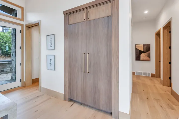 Built-in cabinetry with modern hardware, natural wood-finish flooring, and white trim