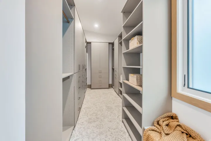 Custom closet system featuring built-in shelving, hanging rods, and drawers