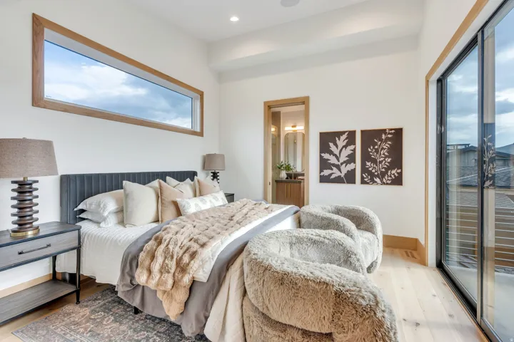 Wood-finish flooring with a large transom window and a floor-to-ceiling glass sliding door