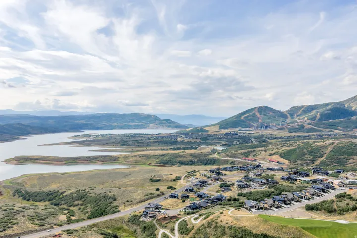 Aerial perspective showcasing a body of water, distant mountain ranges, and residential properties