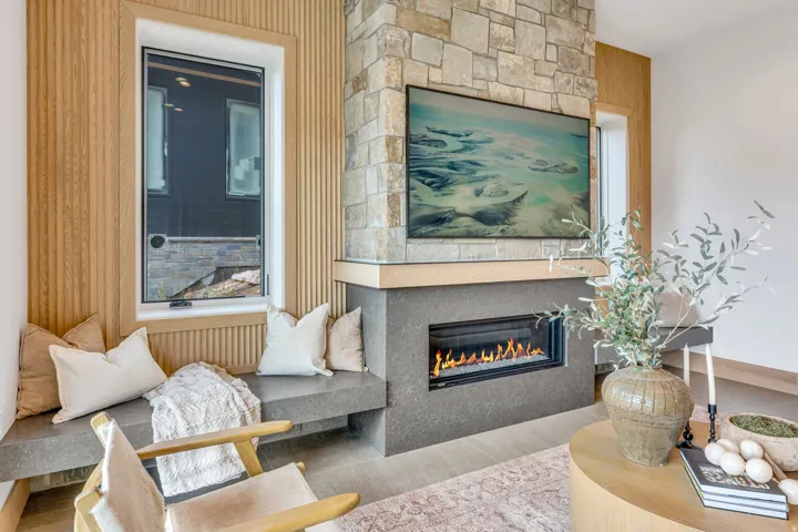 Stone-clad fireplace with a dark gray hearth and a built-in linear electric fireplace