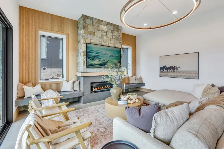 Stone-clad fireplace with a built-in linear electric insert, wood-slat accent wall, and integrated window seating