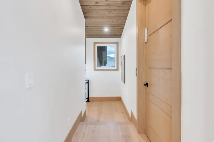Wood-finish ceiling panels, light wood-finish flooring, and white wall finishes