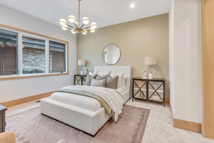 Recessed lighting, large multi-pane windows with wood trim, wood-finish flooring, and a contemporary chandelier