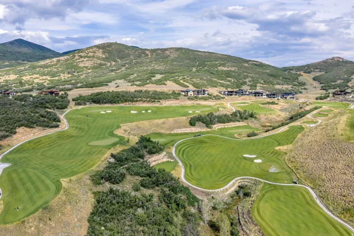 Expansive golf course setting featuring multiple greens, sand traps, and cart paths