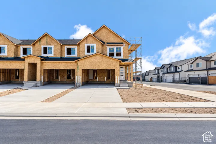 Multi-unit residential structure featuring wood-sheathing exterior, multi-gabled roofline, asphalt shingle roofing, and concrete driveways