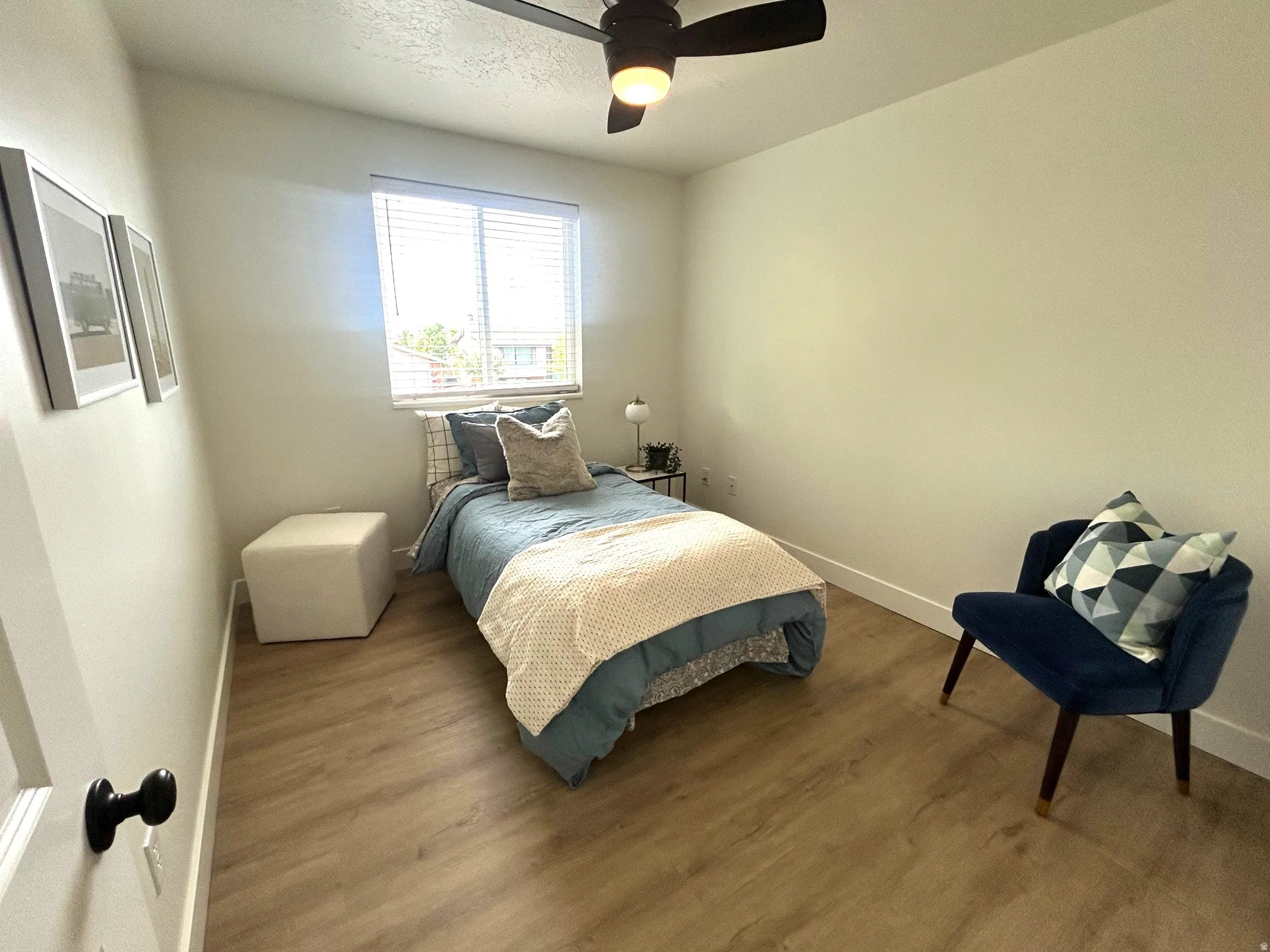 Wood-finish flooring, overhead ceiling fan with lighting, and a window with horizontal blinds