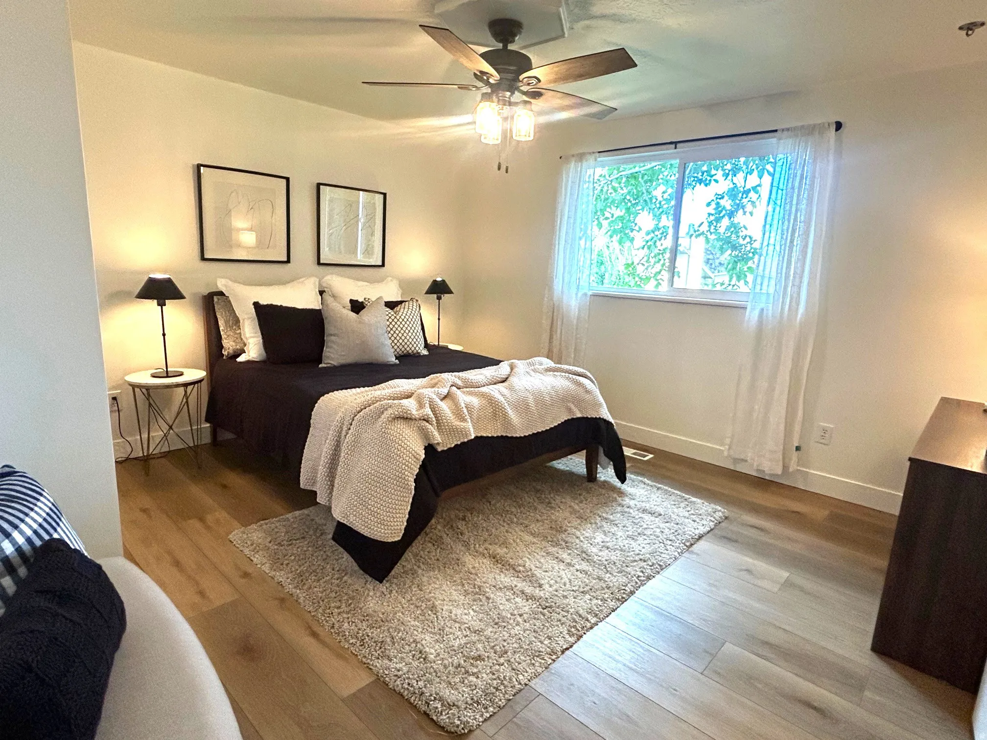 Wood-finish flooring, ceiling fan with light fixture, window with drapes, and recessed lighting