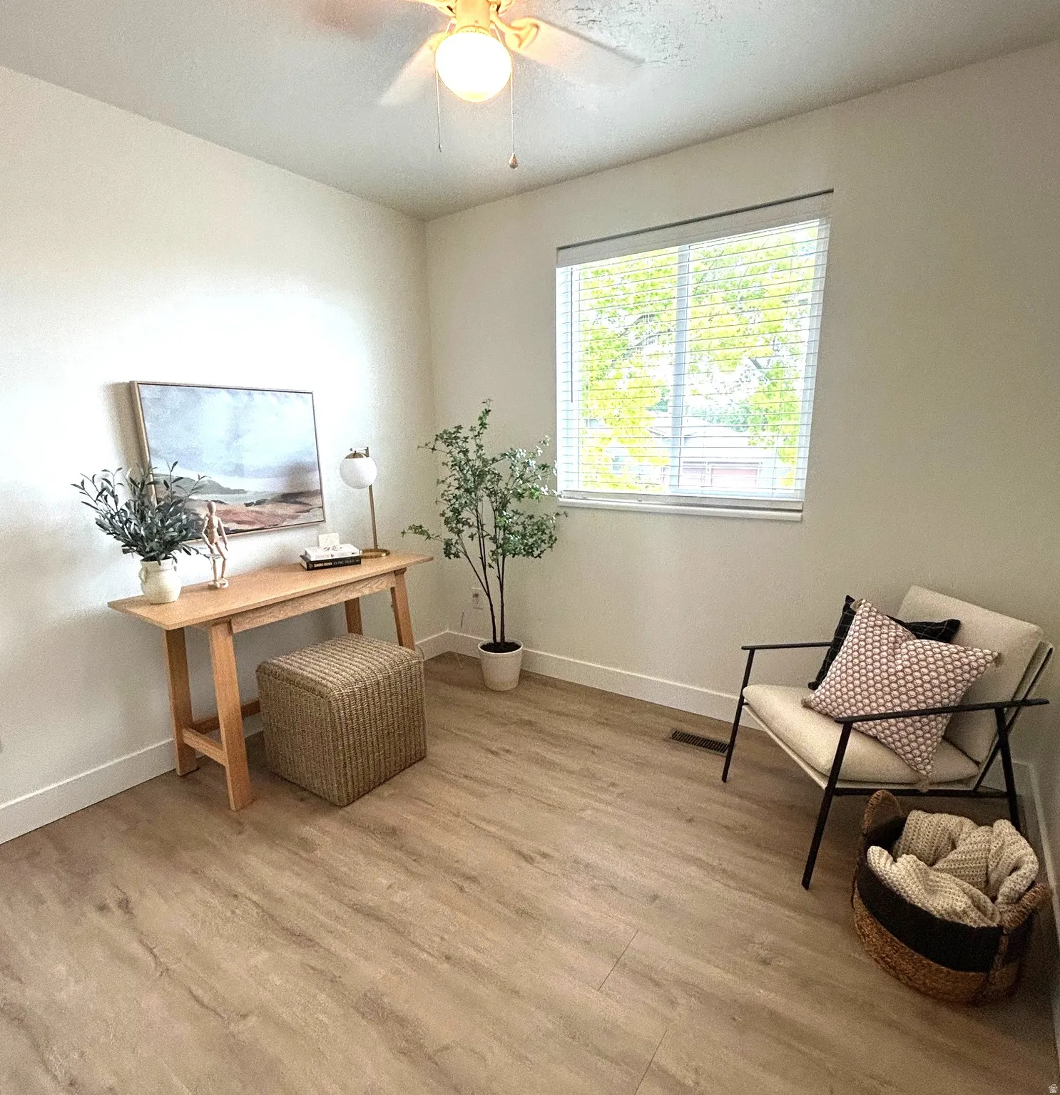Recessed window with blinds, wood-finish flooring, ceiling fan with integrated lighting, and white baseboards