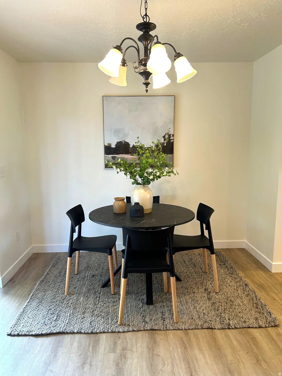 Recessed lighting, wood-finish flooring, and a chandelier with frosted glass shades